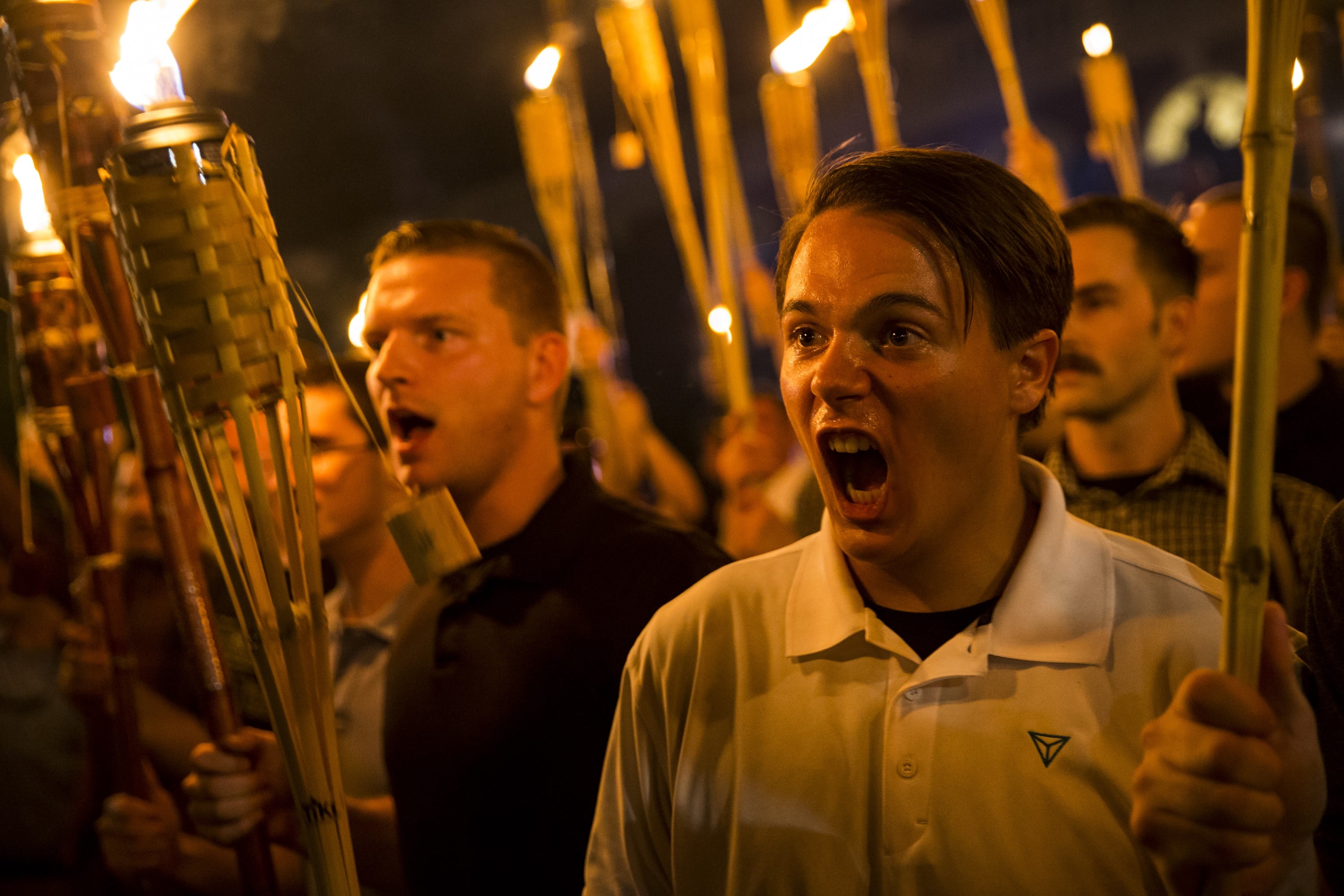 CHARLOTTESVILLE, USA - AUGUST 11: Peter Cvjetanovic (R) along with Neo Nazis, Alt-Right, and White Supremacists encircle and chant at counter protestors at the base of a statue of Thomas Jefferson after marching through the University of Virginia campus with torches in Charlottesville, Va., USA on August 11, 2017. (Photo by Samuel Corum/Anadolu Agency/Getty Images) / Anadolu / Getty Images